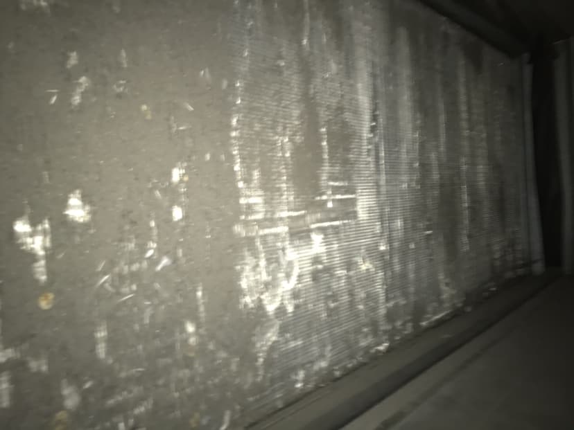 Close-up of a dirty HVAC system filter with dust and grime buildup, requiring immediate cleaning or replacement. This serves as a perfect example of the necessity for regular coil cleaning to maintain your system's efficiency.
