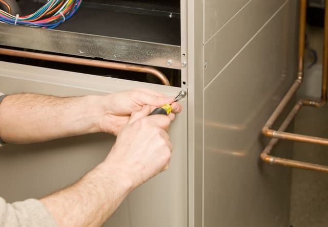 A man working on a gas furnace.